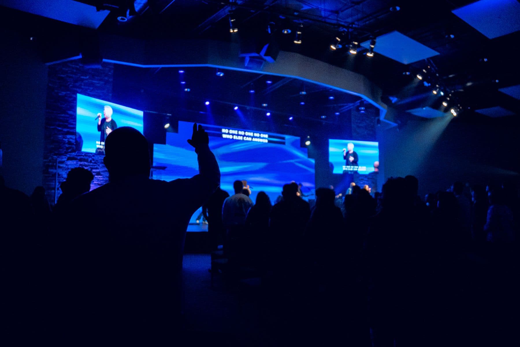 A Sunday service at Cornerstone — the room standing in worship, hands raised